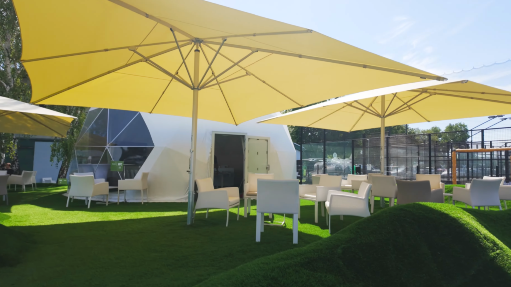 Beschatteter Außenbereich des Mini-Golfplatzes Stroke in Wien mit XXL-Glasfaserschirmen.
