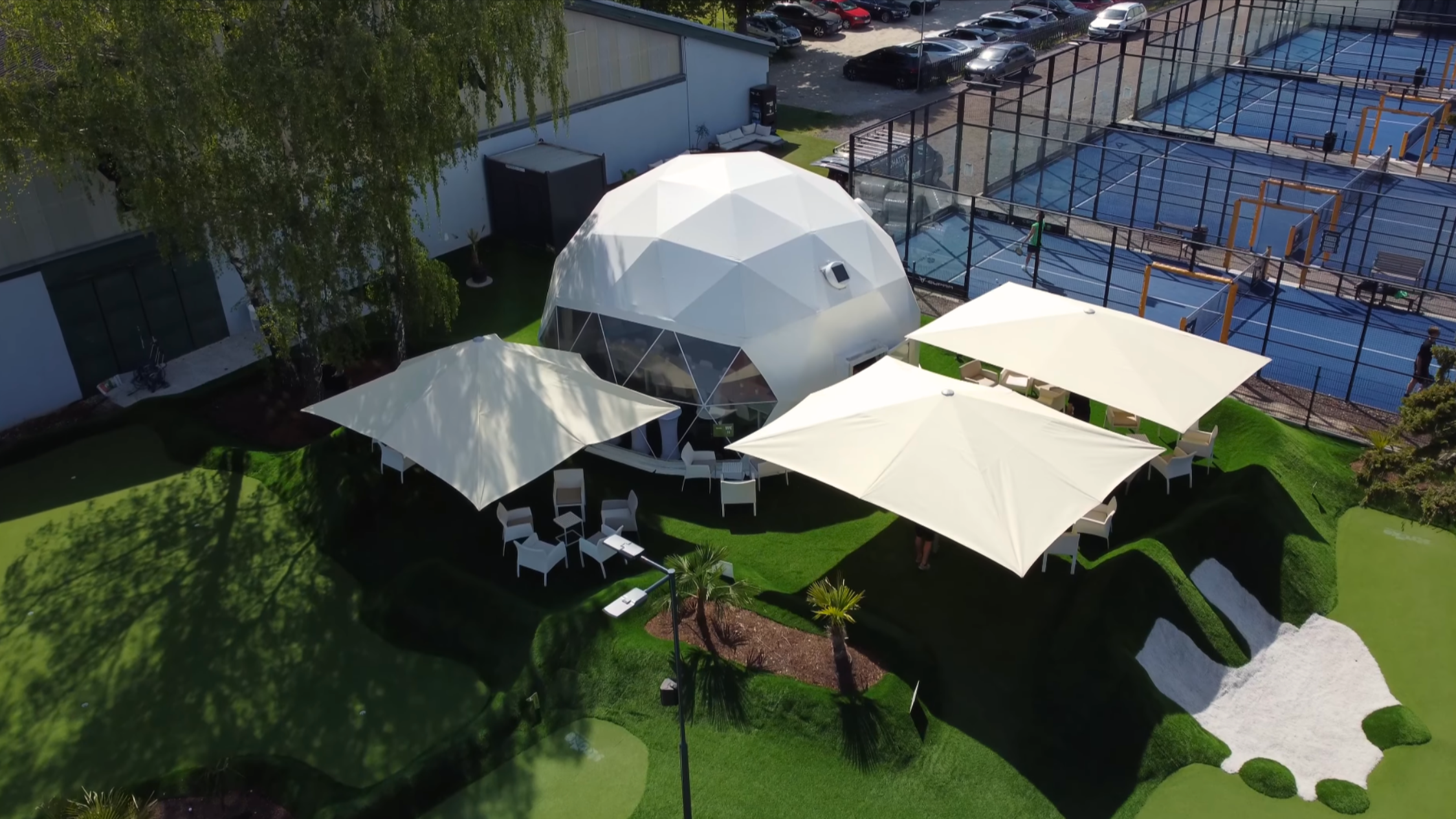 Pausenbereich des Minigolf-Platzes Stroke in Wien mit XXL-Glasfaser Sonnenschirmen.